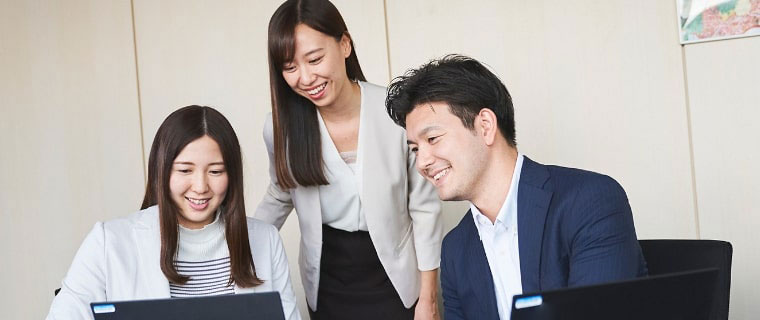 笑うながらパソコンをみる男女